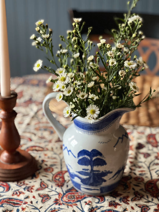 Blue Willow pitcher as a vase on a table