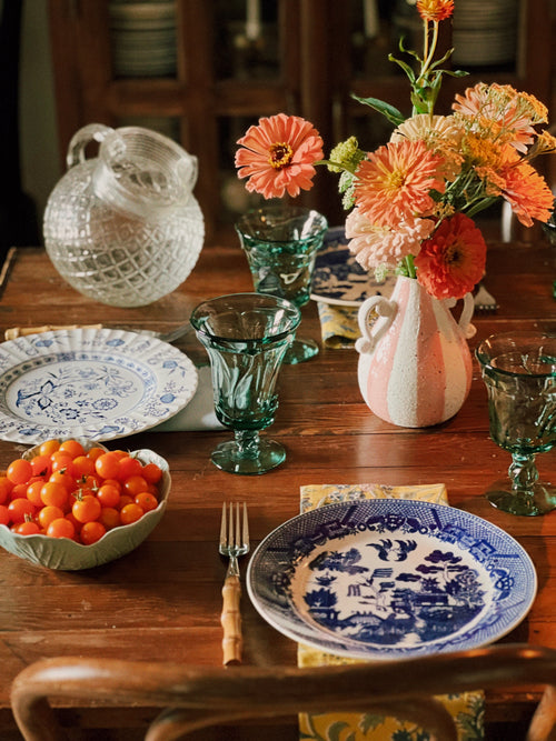 cut glass pitcher on a table set for dinner with a floral arrangement
