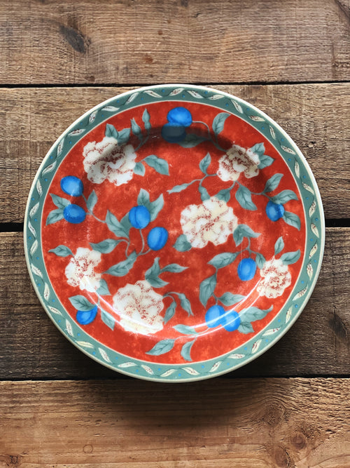 Decorative plate with floral design on a wooden surface