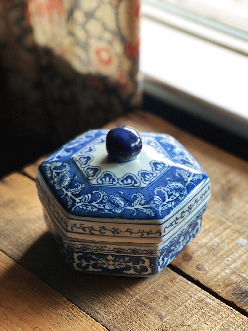 Blue and white hexagonal ceramic container on a wooden surface