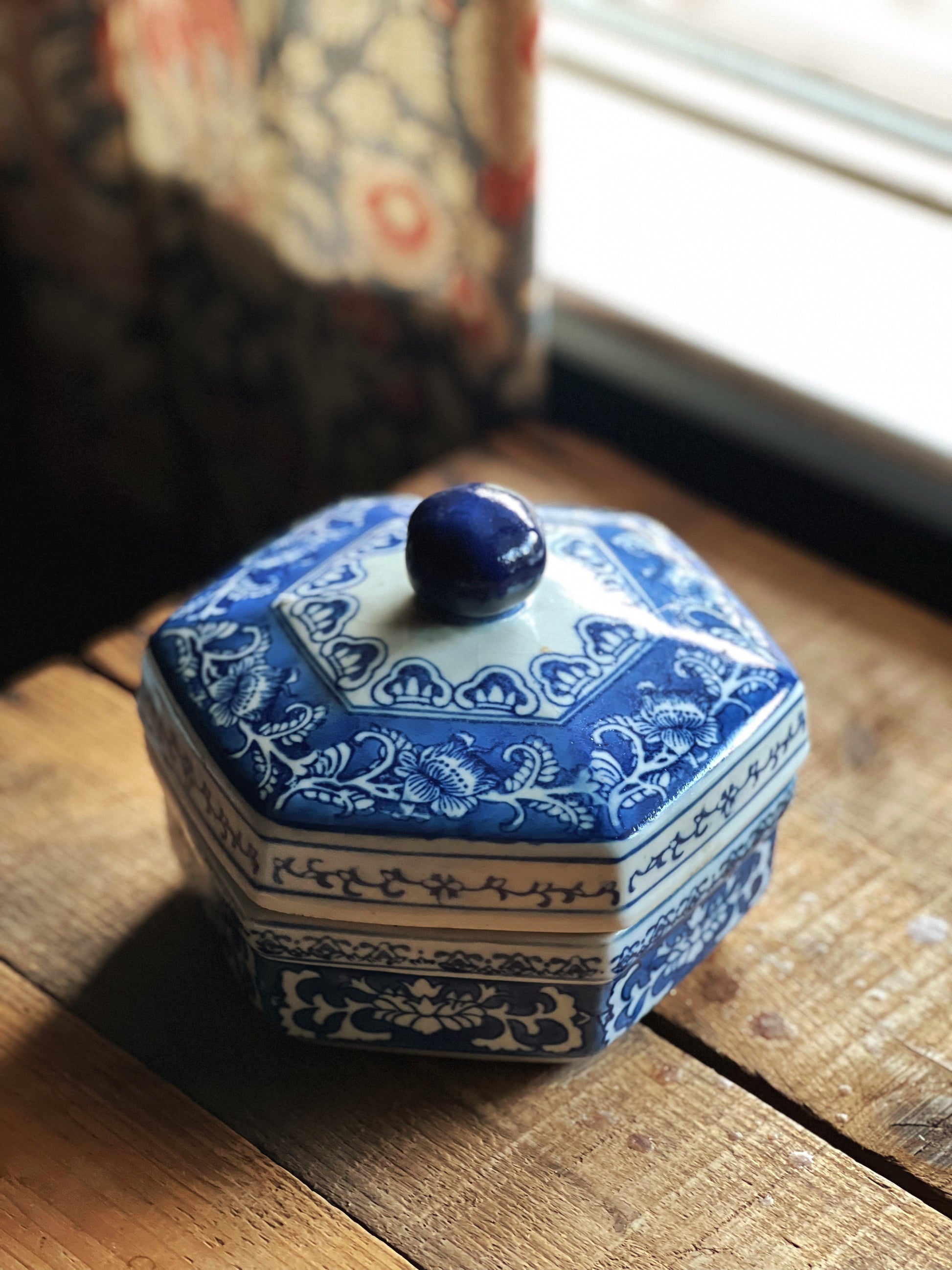 Blue and white hexagonal ceramic container on a wooden surface