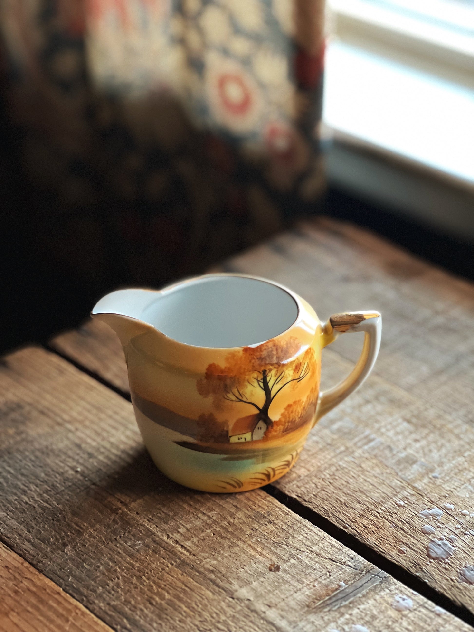 hand painted creamer with a landscape design