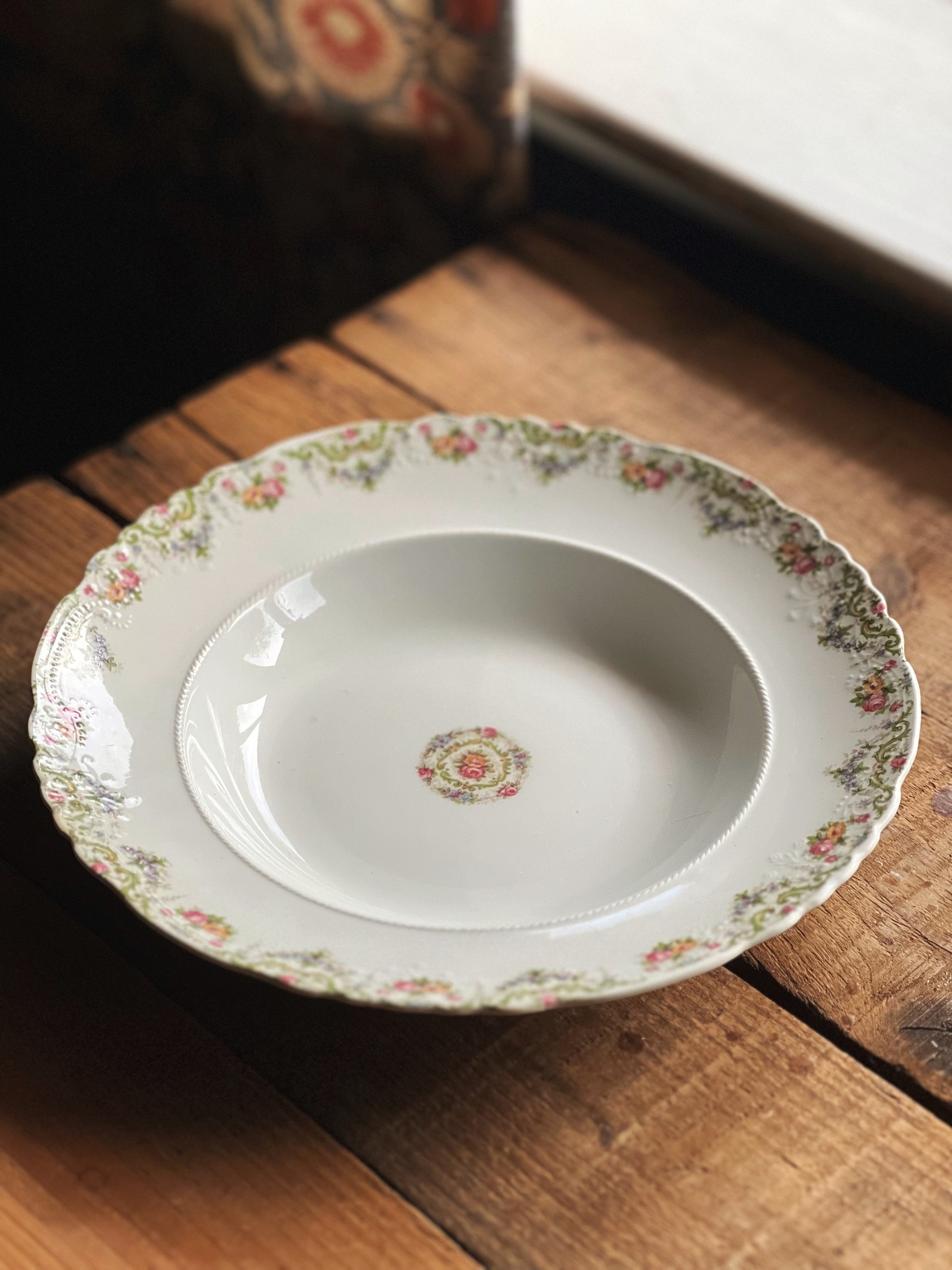 Decorative ceramic bowl with floral pattern on a wooden surface