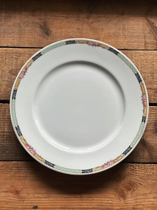 White plate with decorative rim on a wooden surface