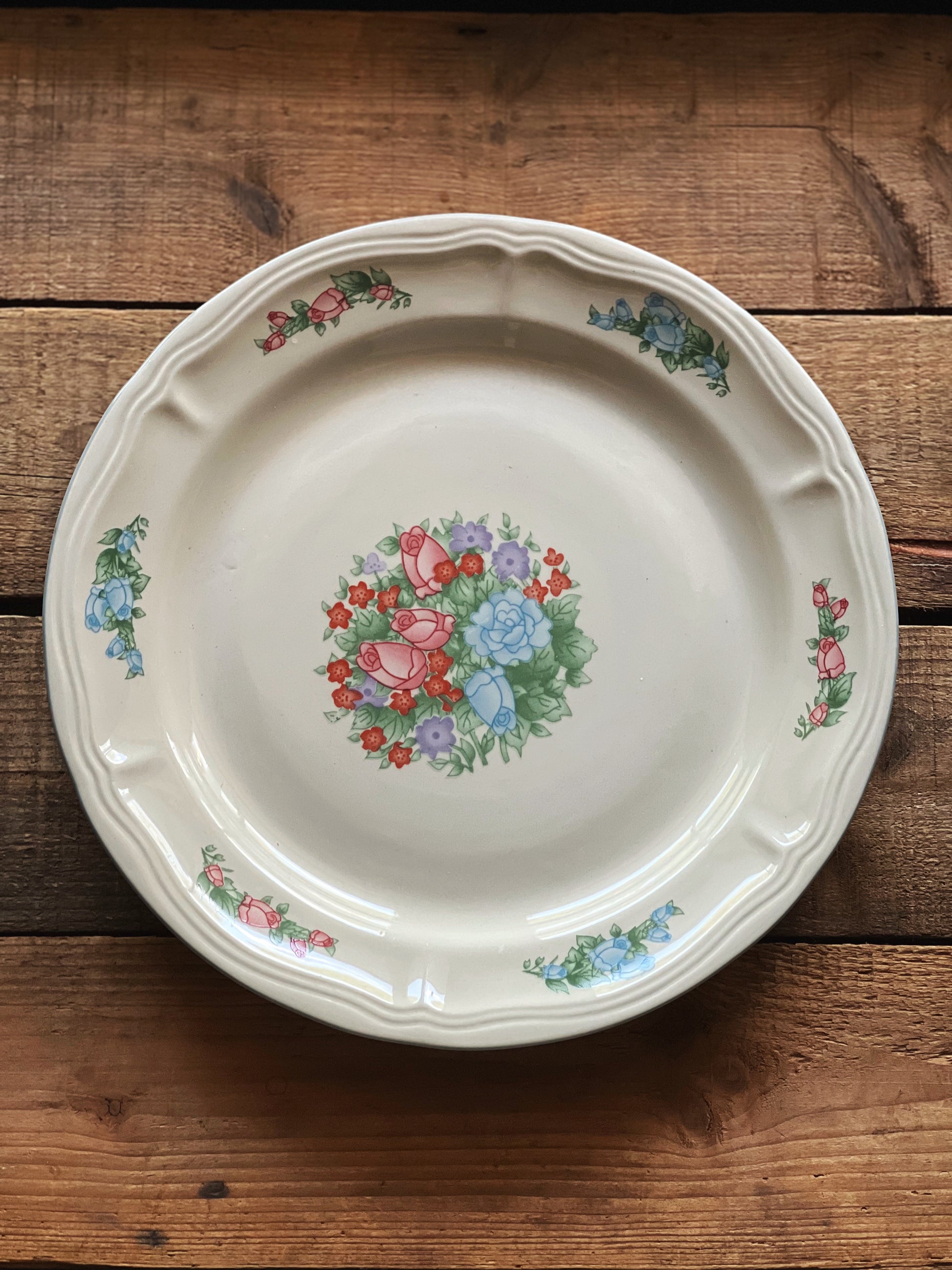 Decorative ceramic plate with floral design on a wooden surface
