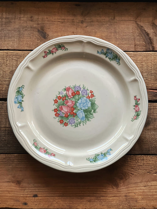 Decorative ceramic plate with floral design on a wooden surface