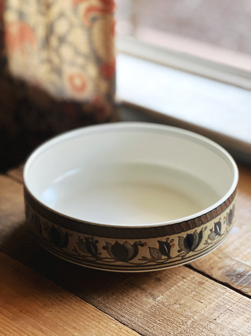 Ceramic bowl with decorative rim on a wooden surface