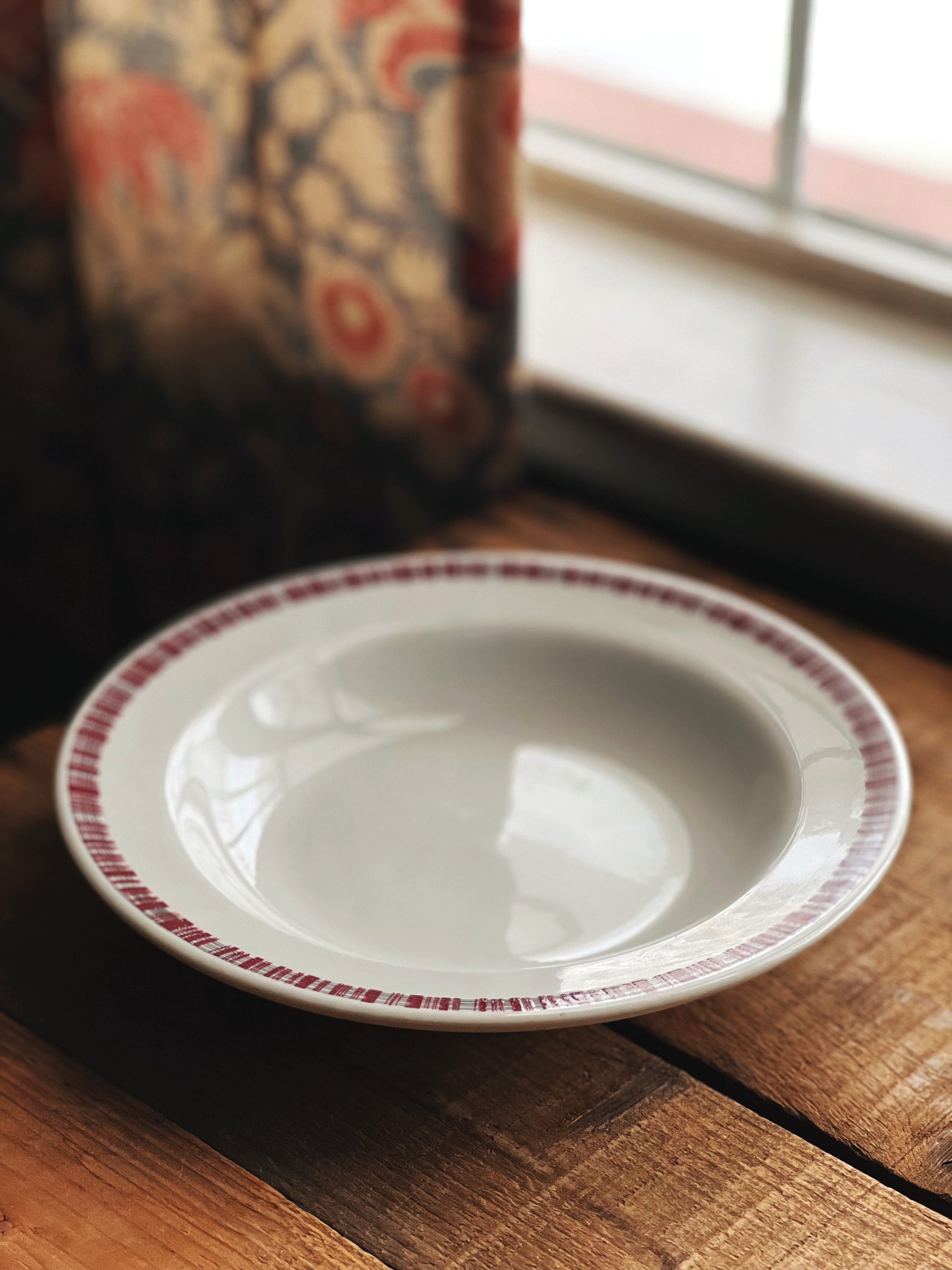 rimmed soup bowl with a marooon and grey design