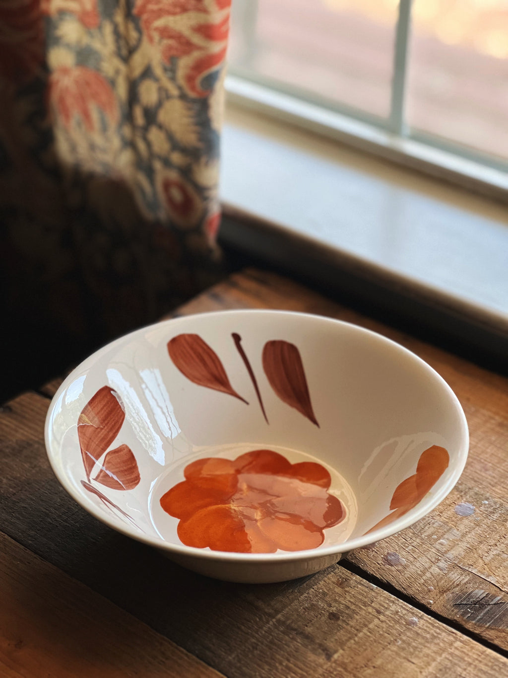 Ceramic bowl with floral design on a wooden surface