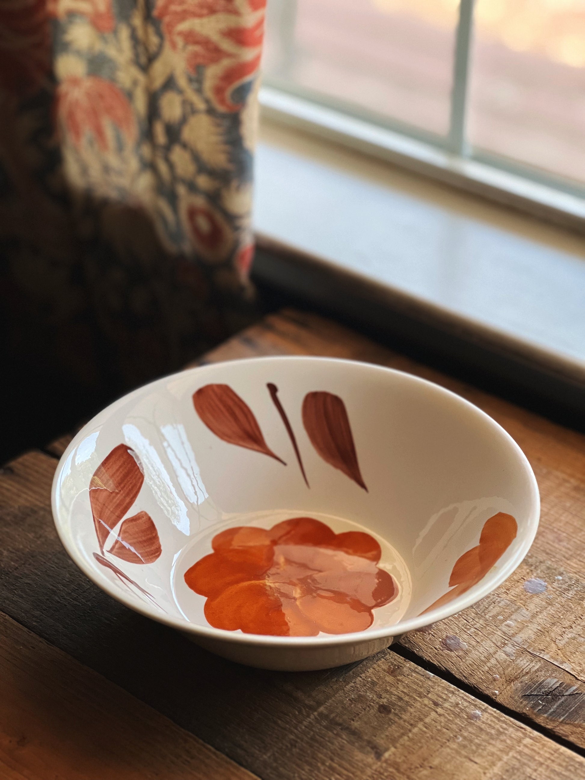 Ceramic bowl with floral design on a wooden surface