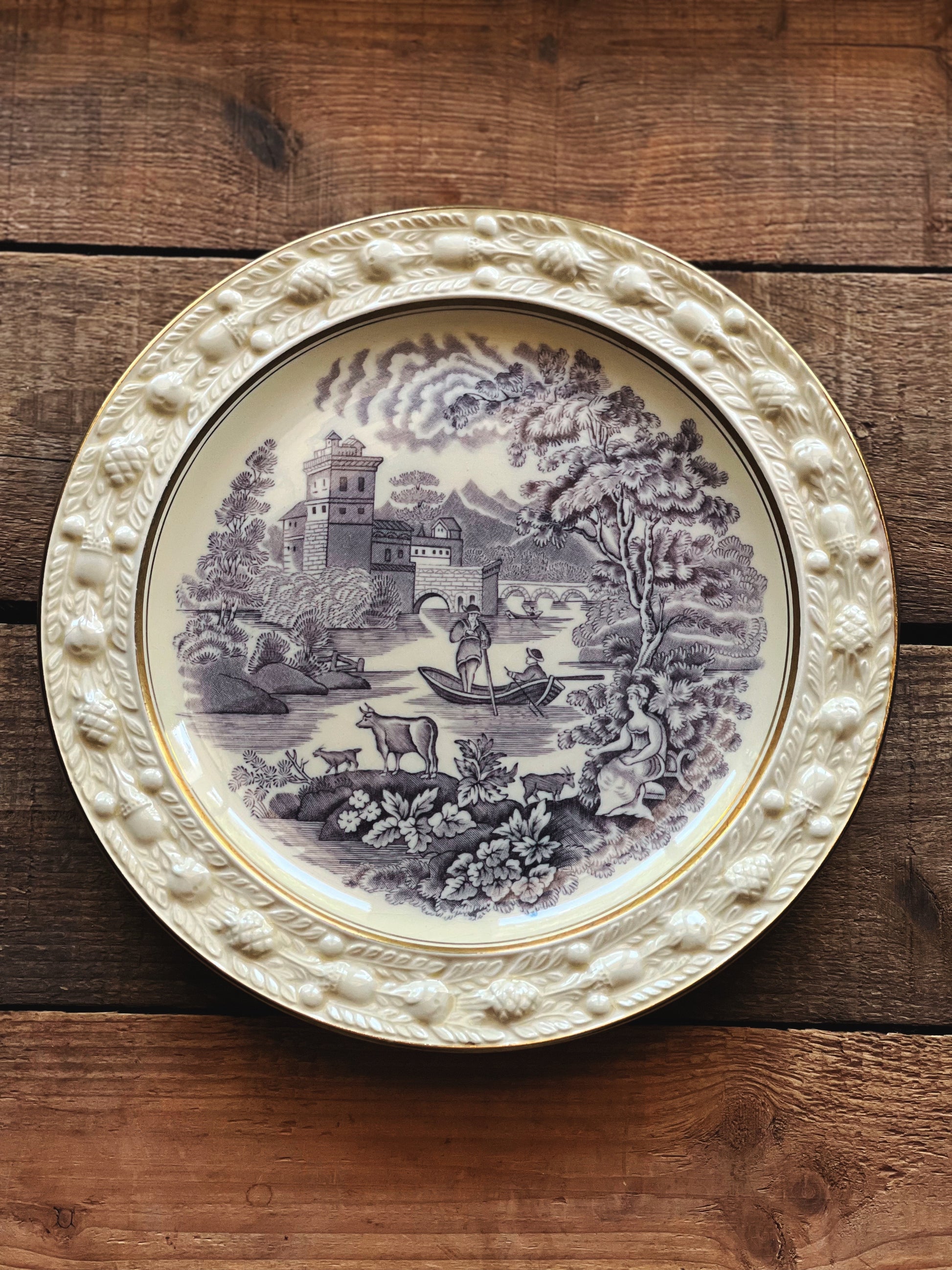 Decorative plate with a landscape design on a wooden surface