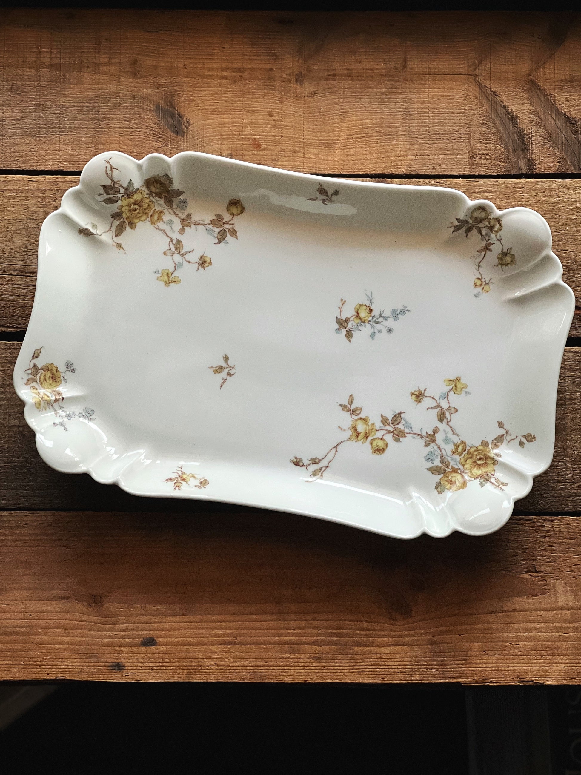 Decorative ceramic platter with floral patterns on a wooden surface