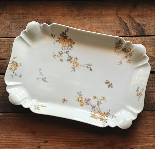 Decorative ceramic tray with floral patterns on a wooden surface