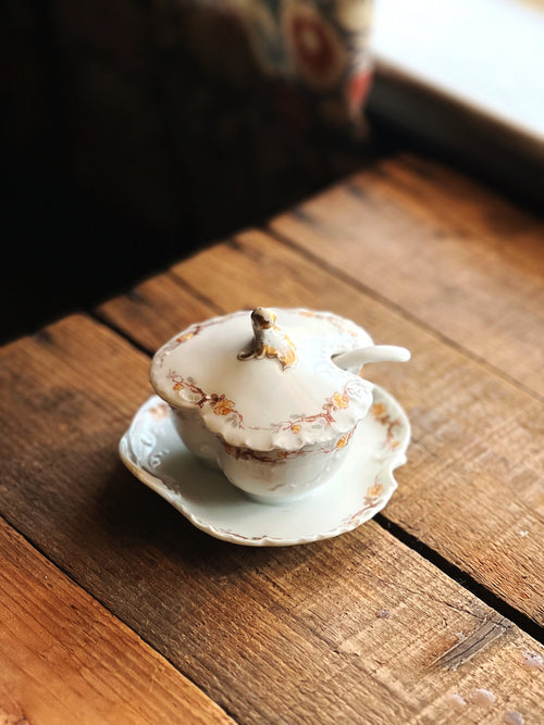Small ceramic cup with lid on a wooden surface