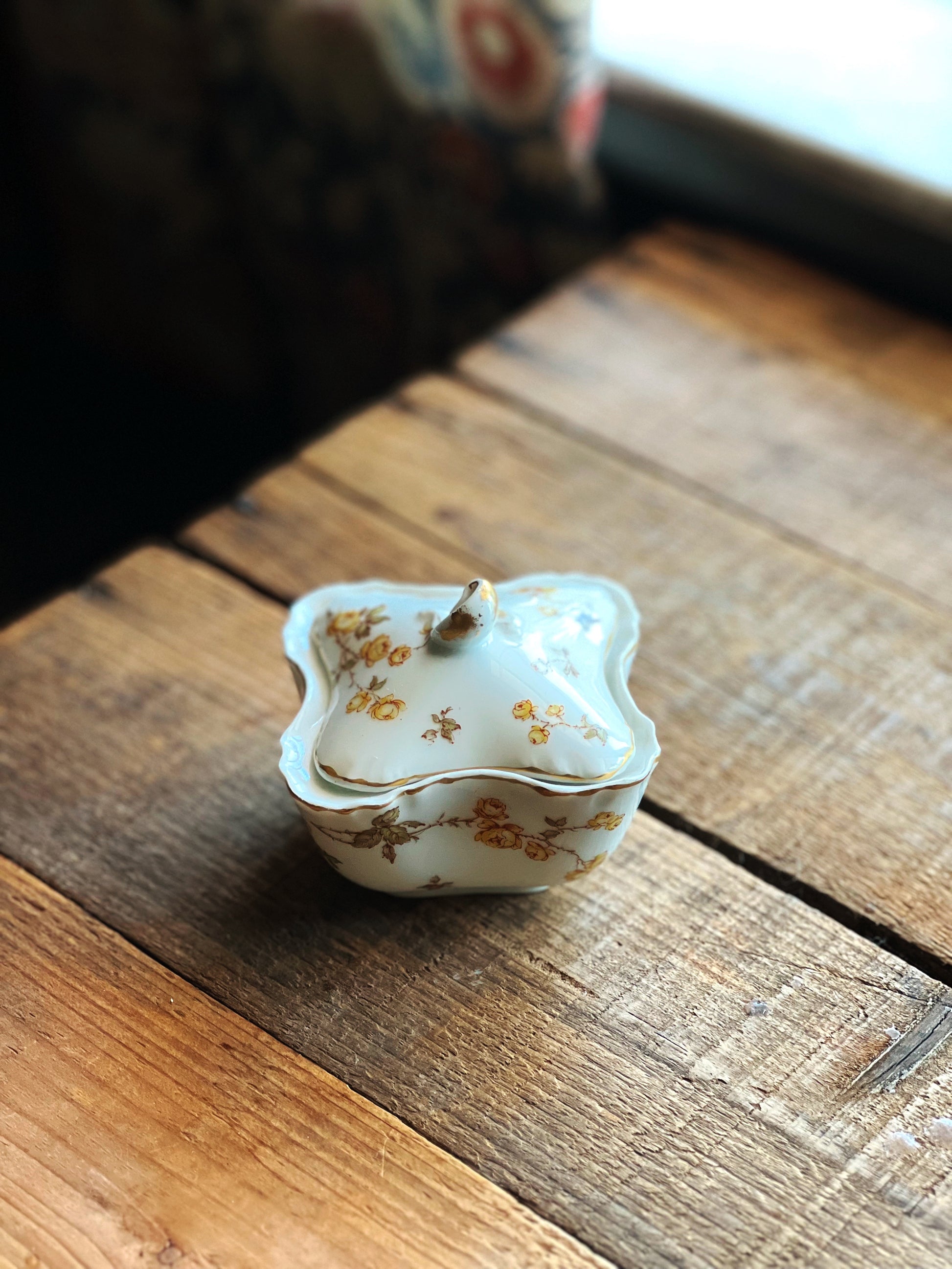 Small decorative ceramic container on a wooden surface