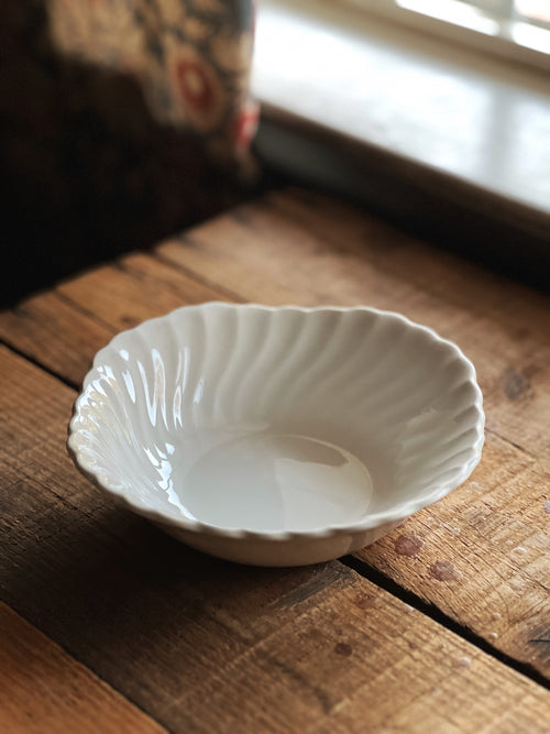 White ceramic bowl on a wooden surface with a blurred background