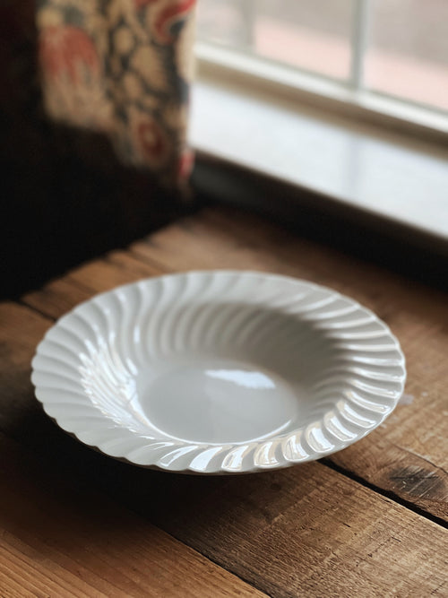 White ceramic plate on a wooden surface with a blurred background