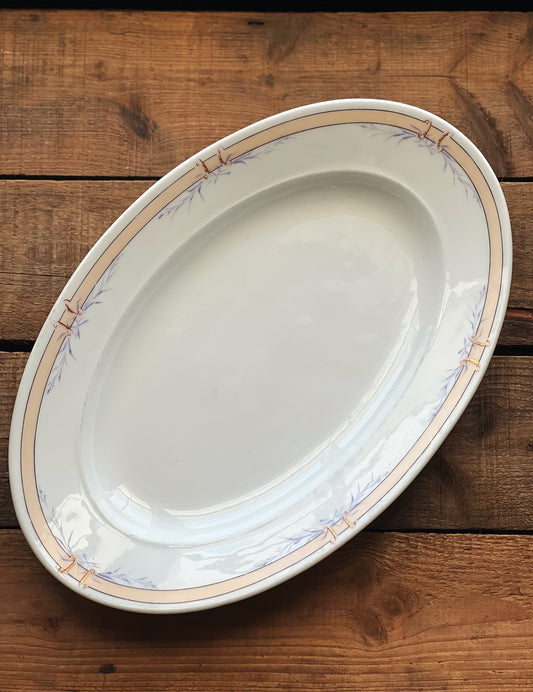 oval serving platter with a pink banded rim