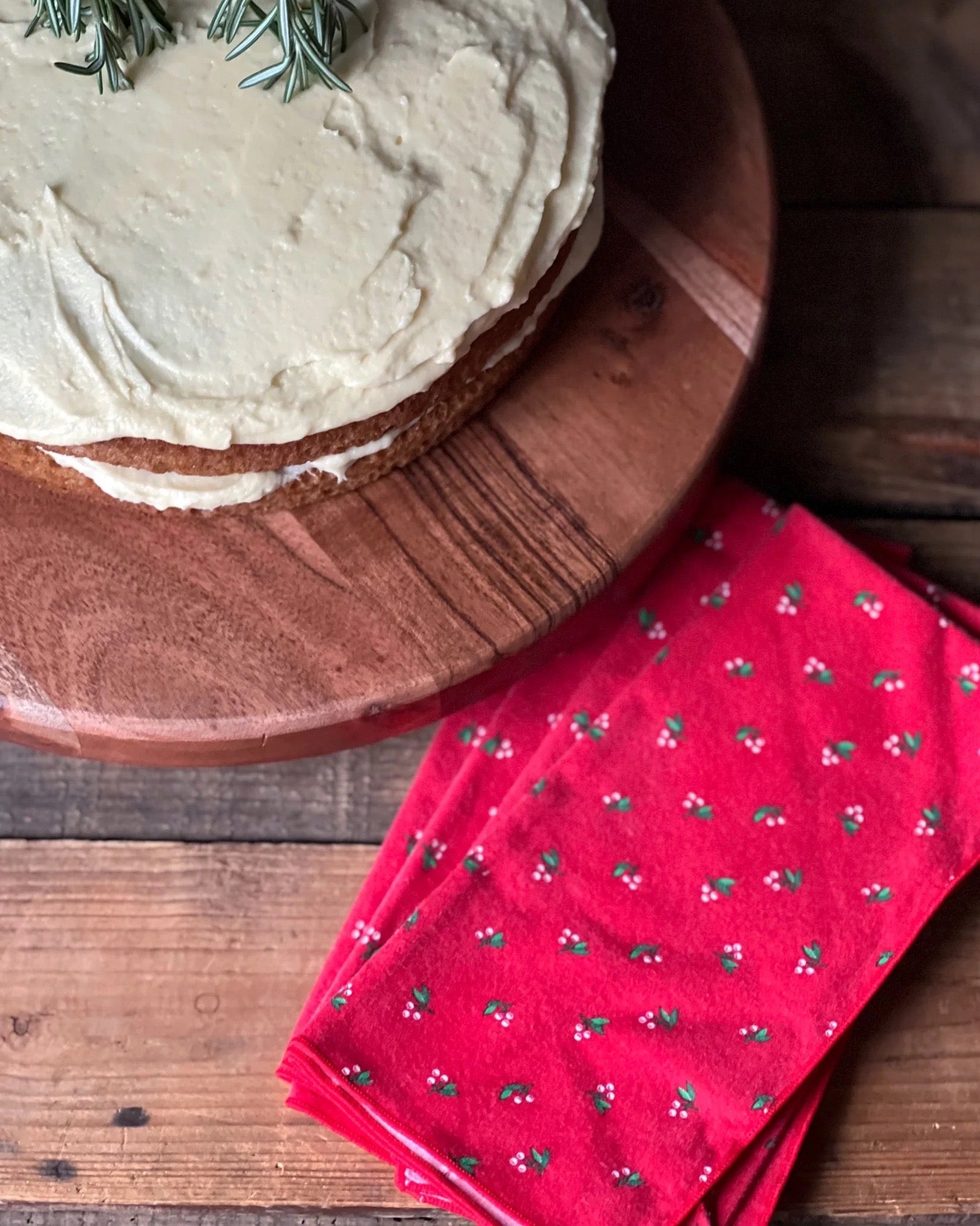 red napkins with holly and berry design all over 