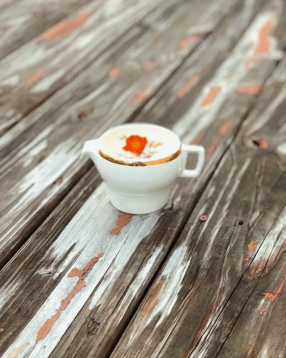 White ceramic cup with a cappuccino on a wooden surface