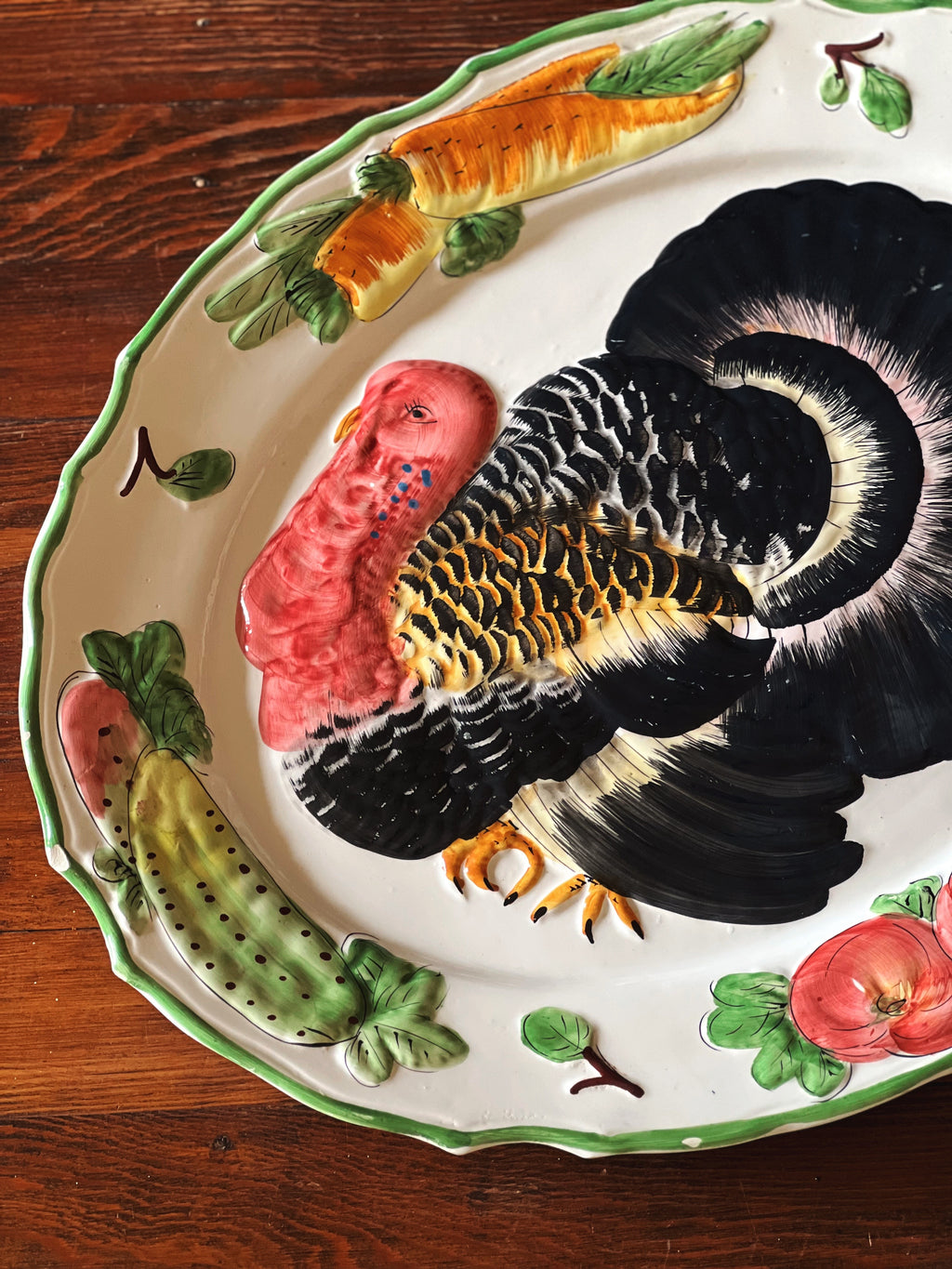Decorative plate with a turkey and vegetables on a wooden surface