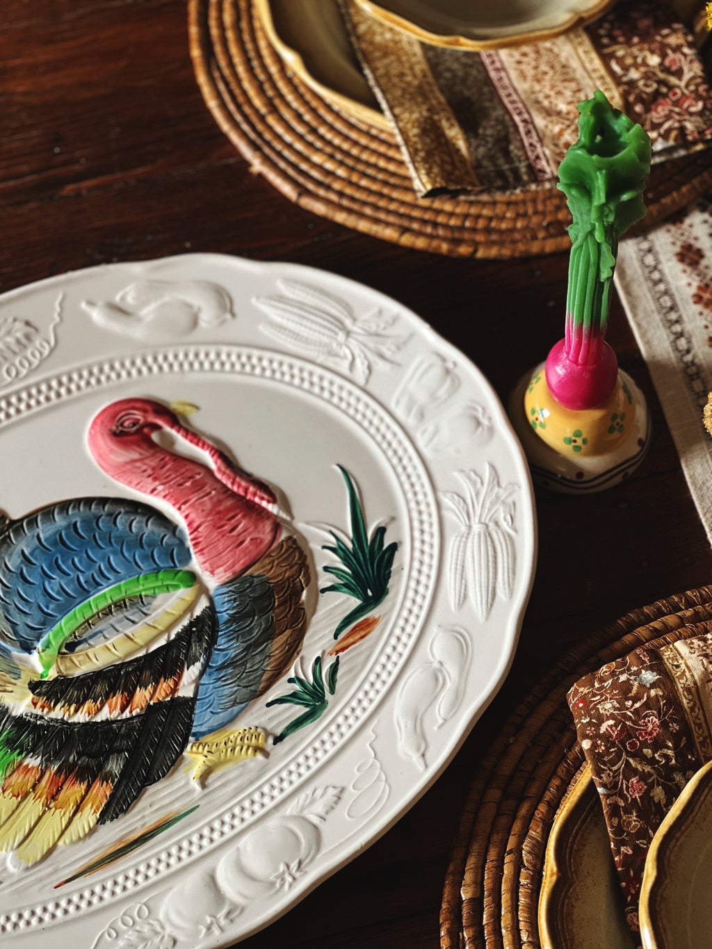 Decorative plate with a colorful turkey design on a wooden table.