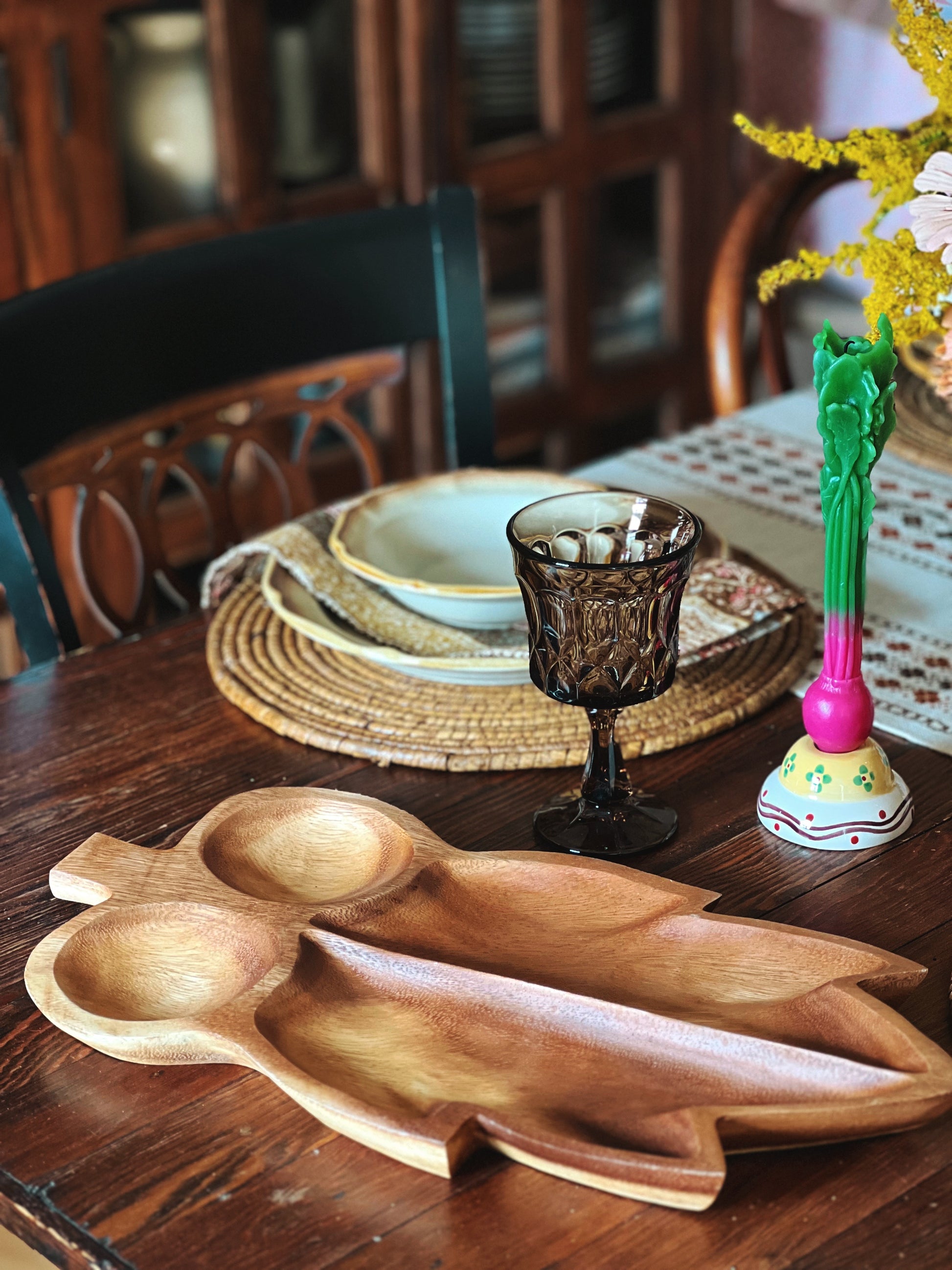 Wooden serving platter on a wooden table with decorative items