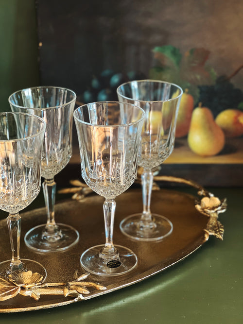 Set of crystal wine glasses on a decorative tray with a blurred background