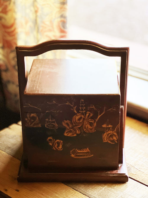 Decorative wooden box with floral designs on a wooden surface