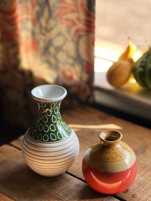 pair of mix match bud vases on a wooden surface
