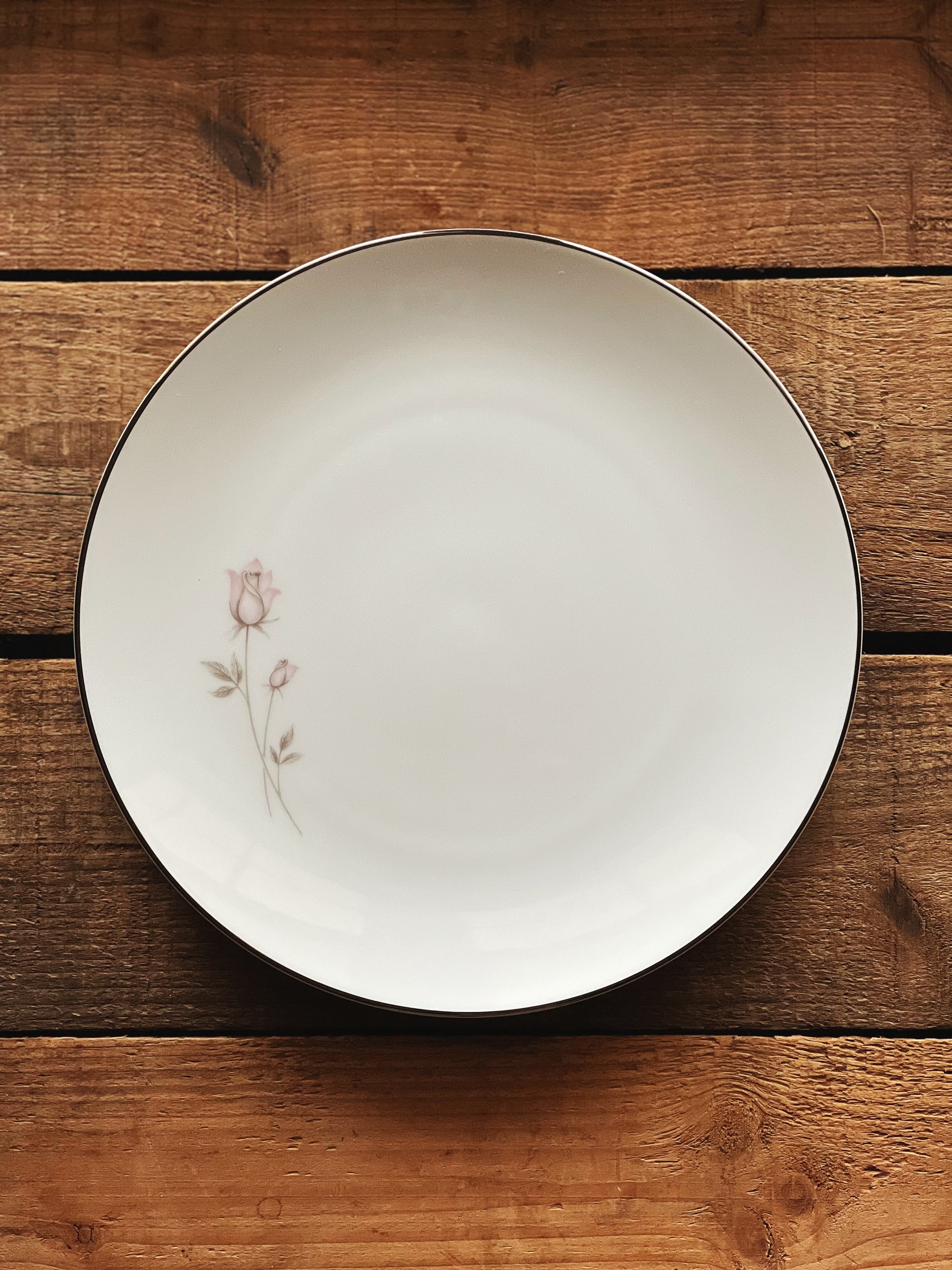 white dinner plate with a pink rose and platinum trim