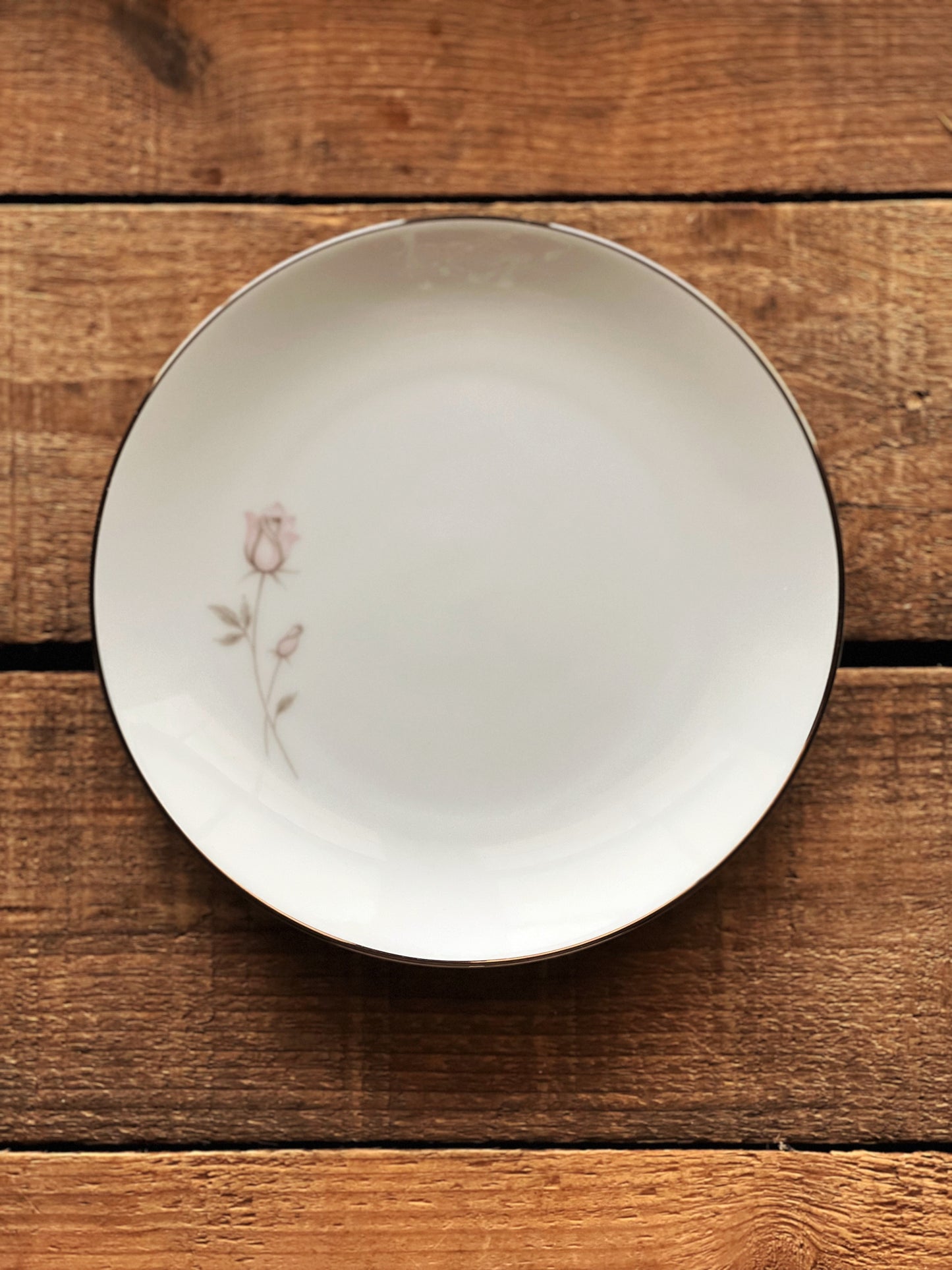 white dinner plates with a pink rose and platinum trim