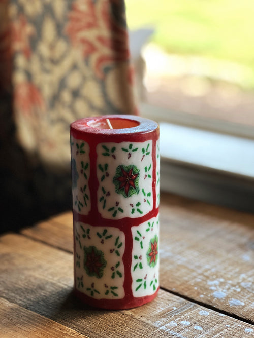 Decorative candle with floral patterns on a wooden surface