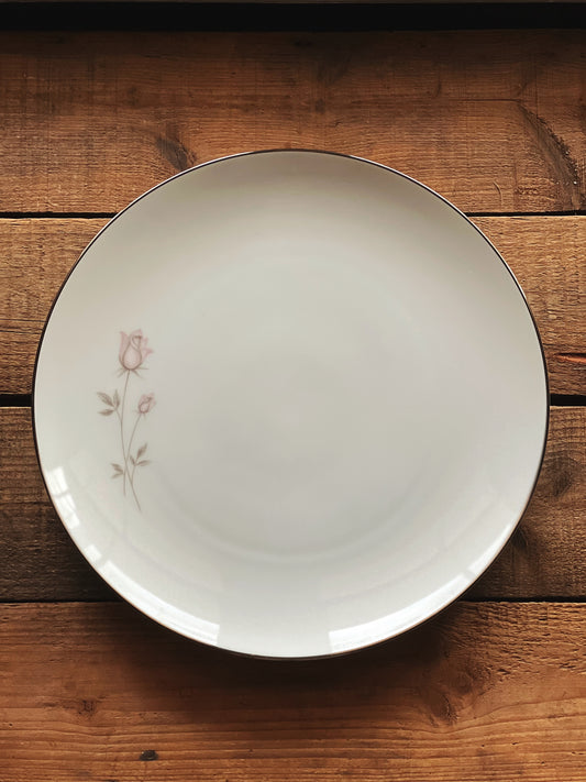 white dinner plate with a pink rose and silver trim