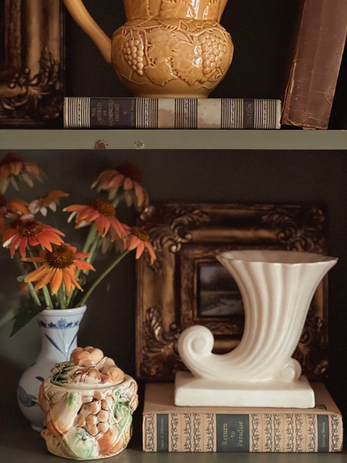 Decorative items including a teapot, books, and vases on a shelf.