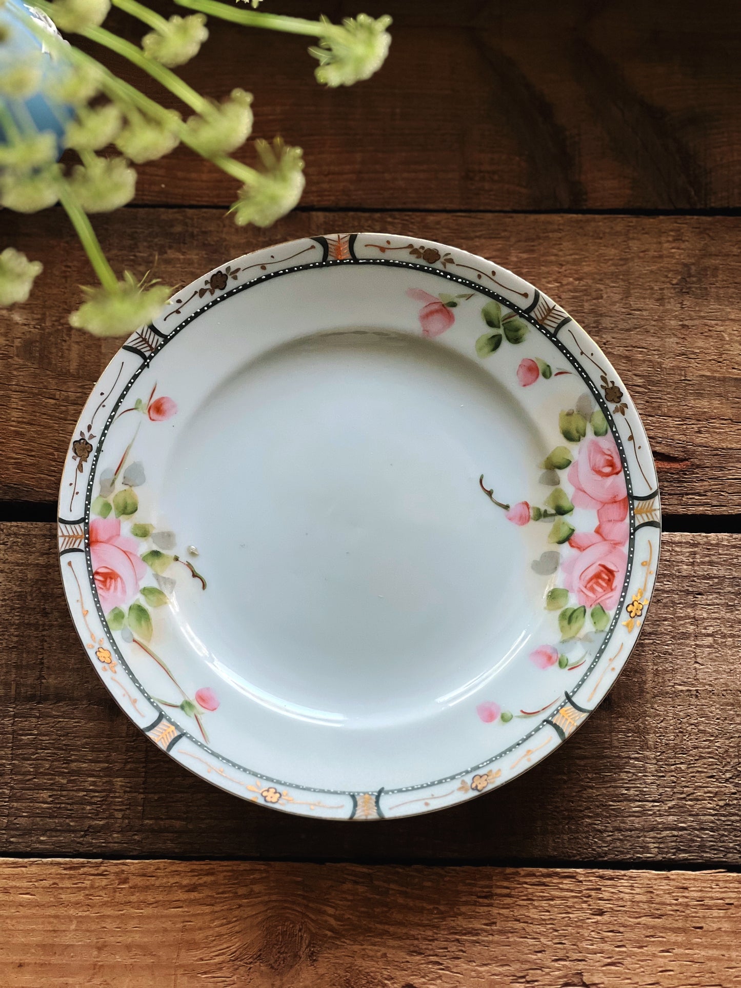 Antique floral salad plate that is hand painted. The floral design is pink and green and trimmed in gold.