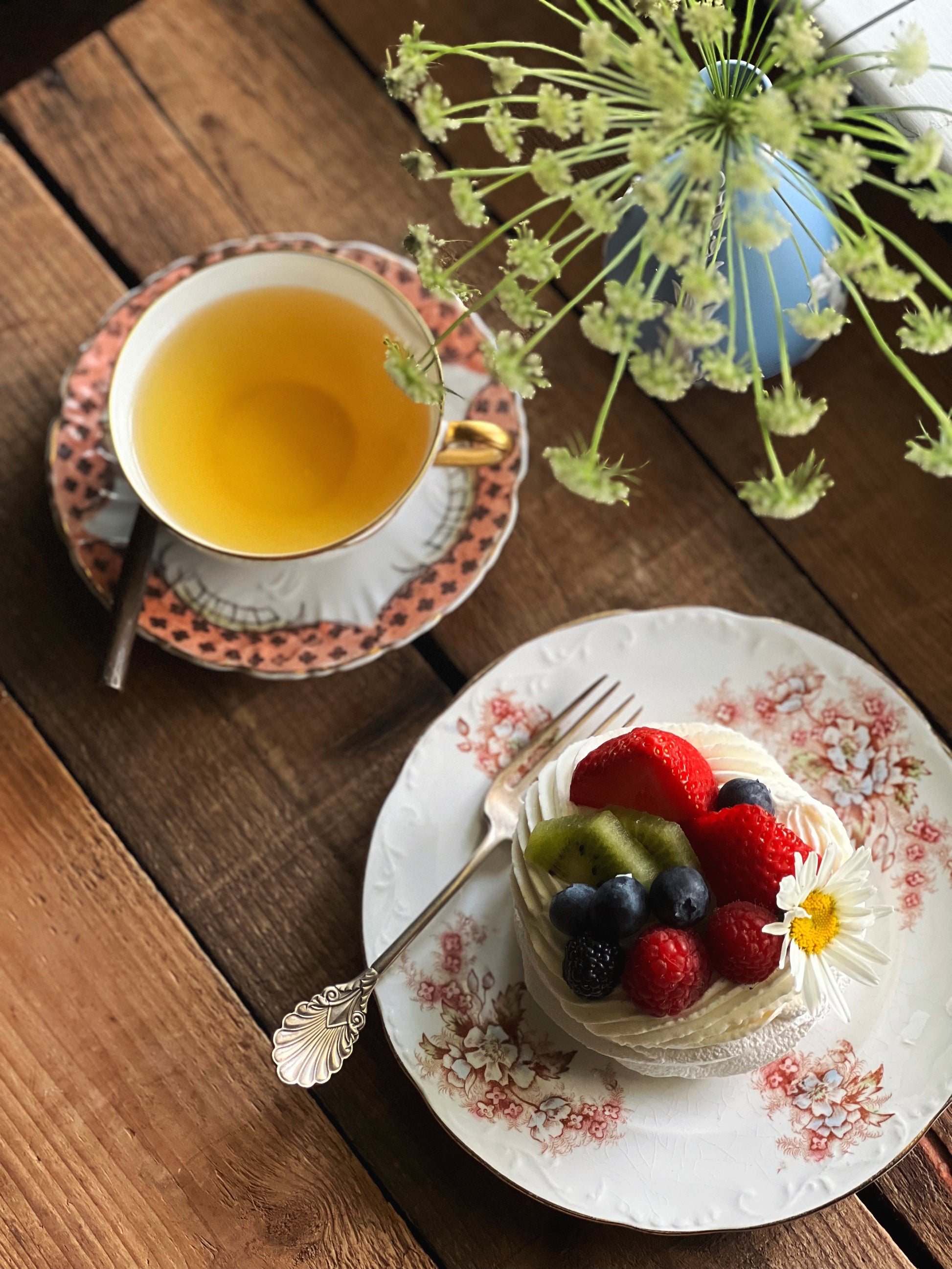 Antique pink floral plate with an embossed rim. It is featured with a pavlova and a cup of tea