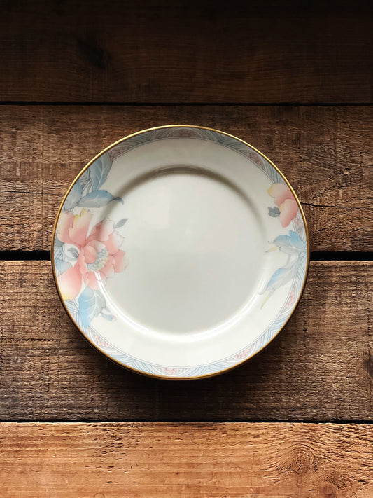 Vintage bread and butter size plate that has a pink and blue floral design on the rim