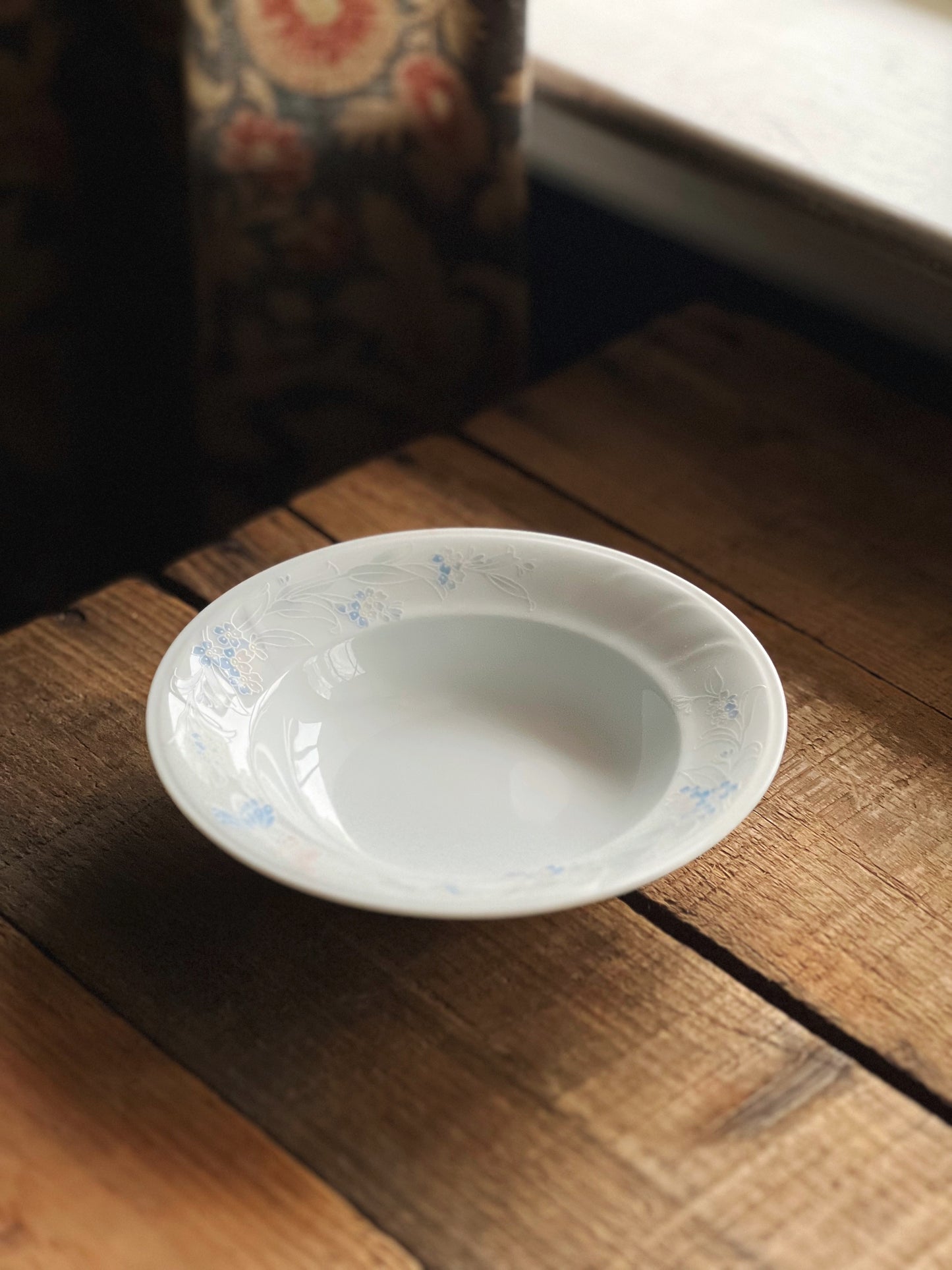 Small vintage berry bowl that is white with a pink and blue rim