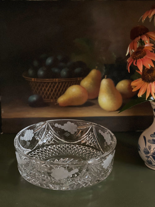 Decorative crystal bowl with pears, sunflowers, and a basket in the background
