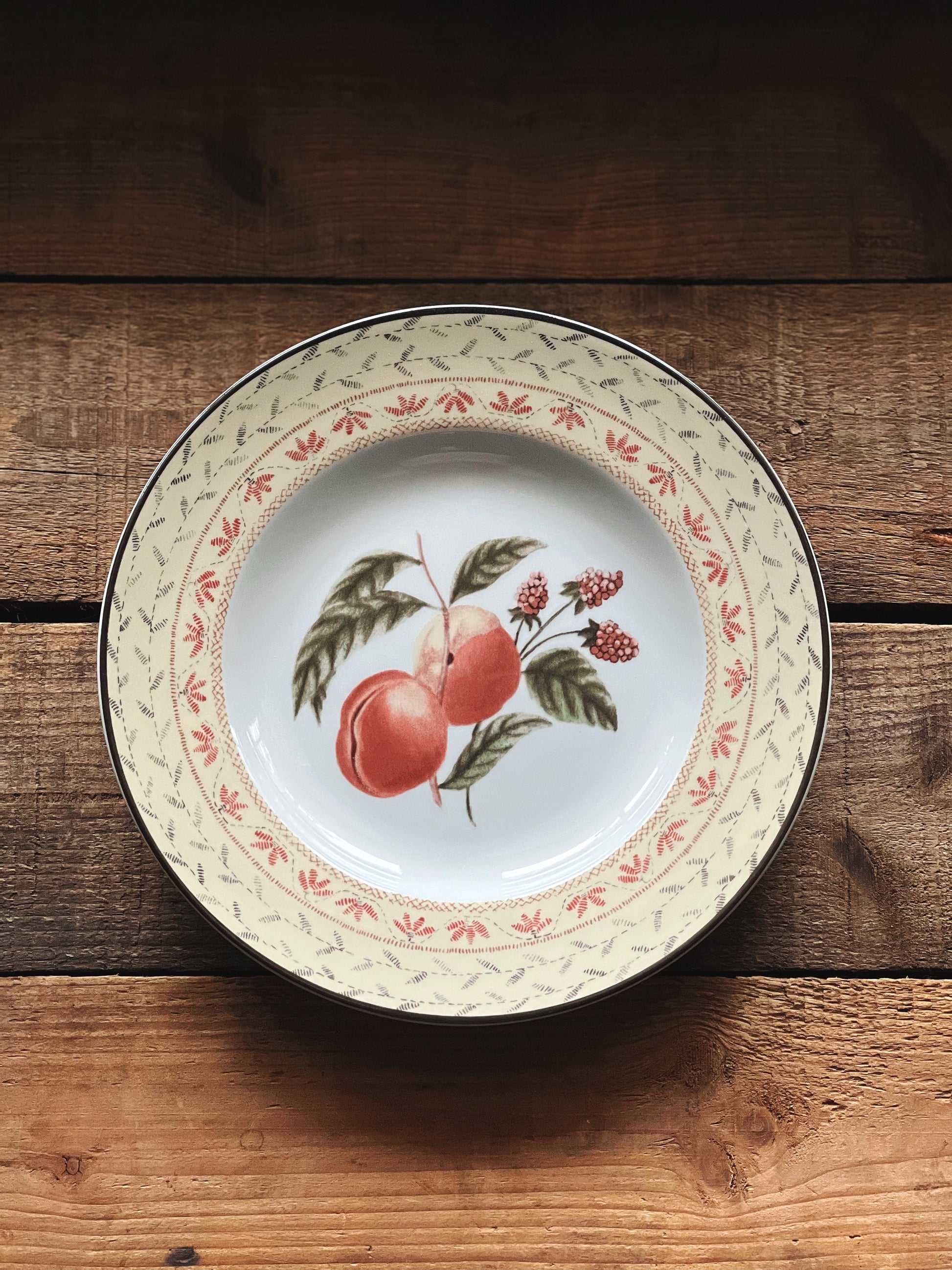 Vintage salad plate with a fruit design featuring peaches and greenery