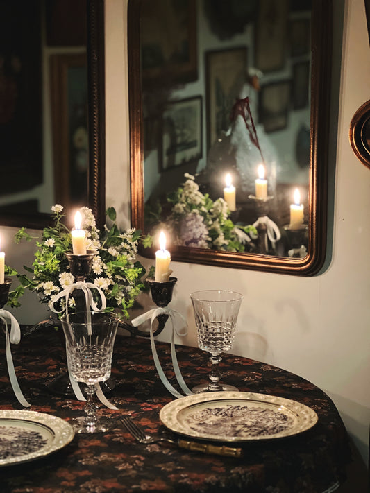 pair of crystal wine glasses on a candlelit dining table