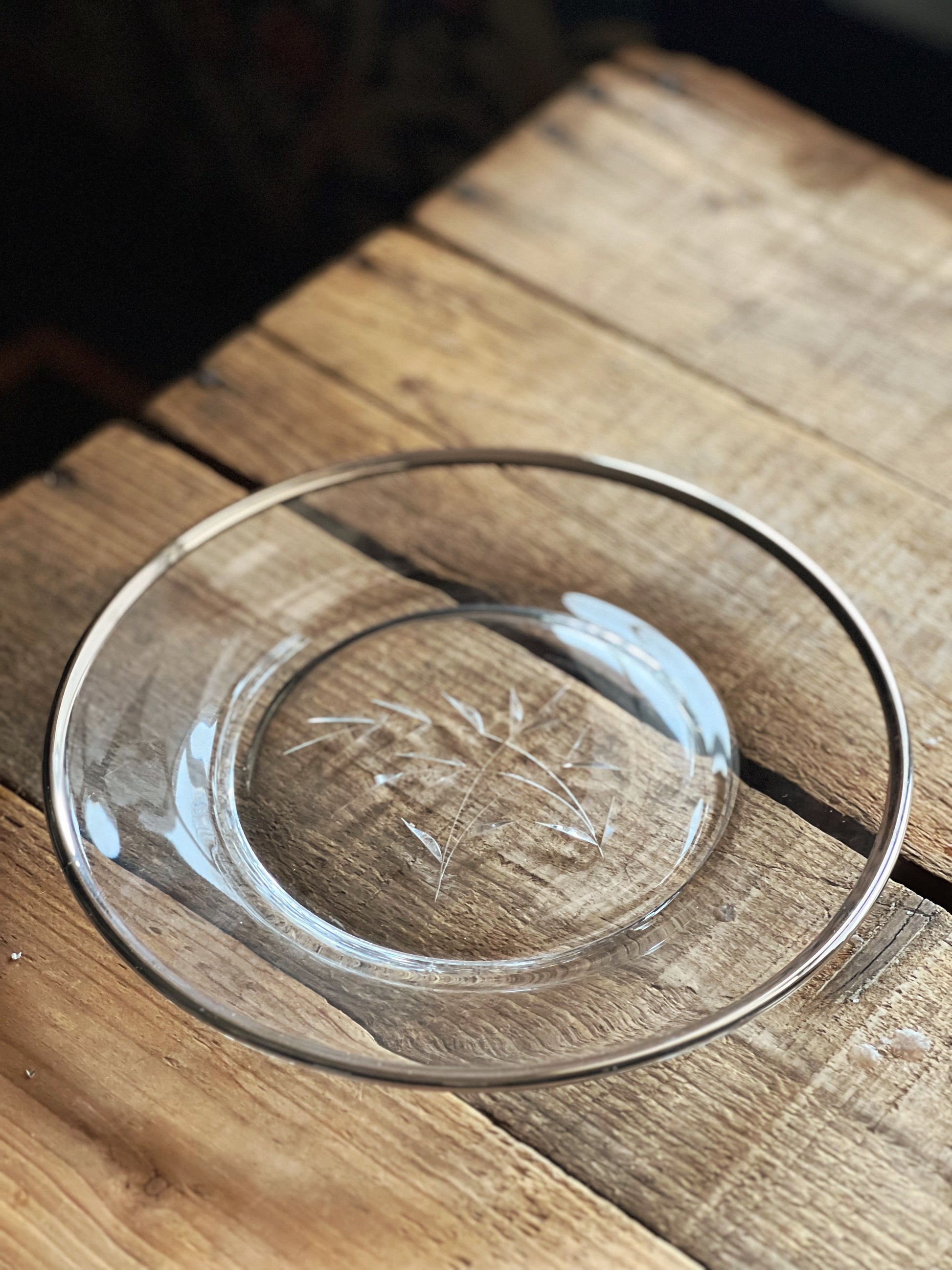 glass salad plate with a silver rim and etched design