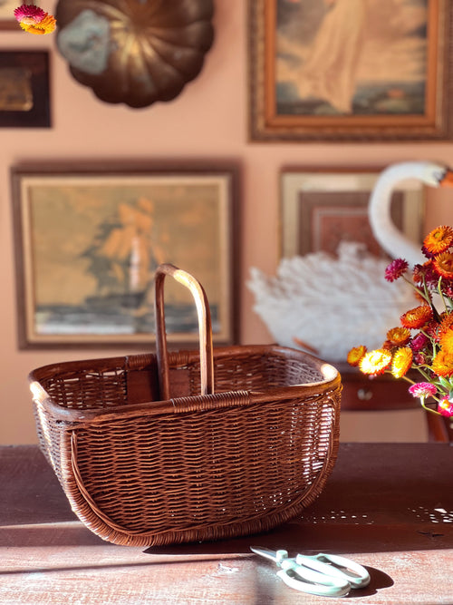 Wicker picnic basket on a table with decorative elements in the background