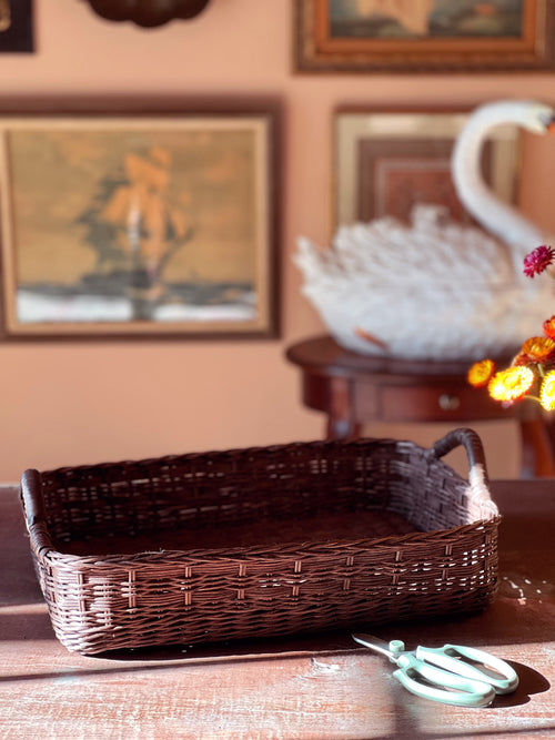 Wicker basket on a wooden surface with a blurred background of a room.