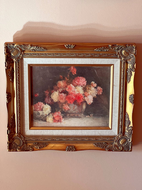 Framed painting of a floral still life on a beige wall