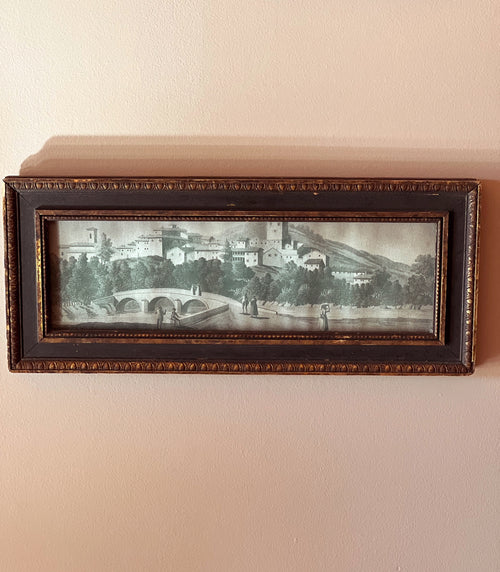 Framed artwork of a scenic landscape on a beige wall