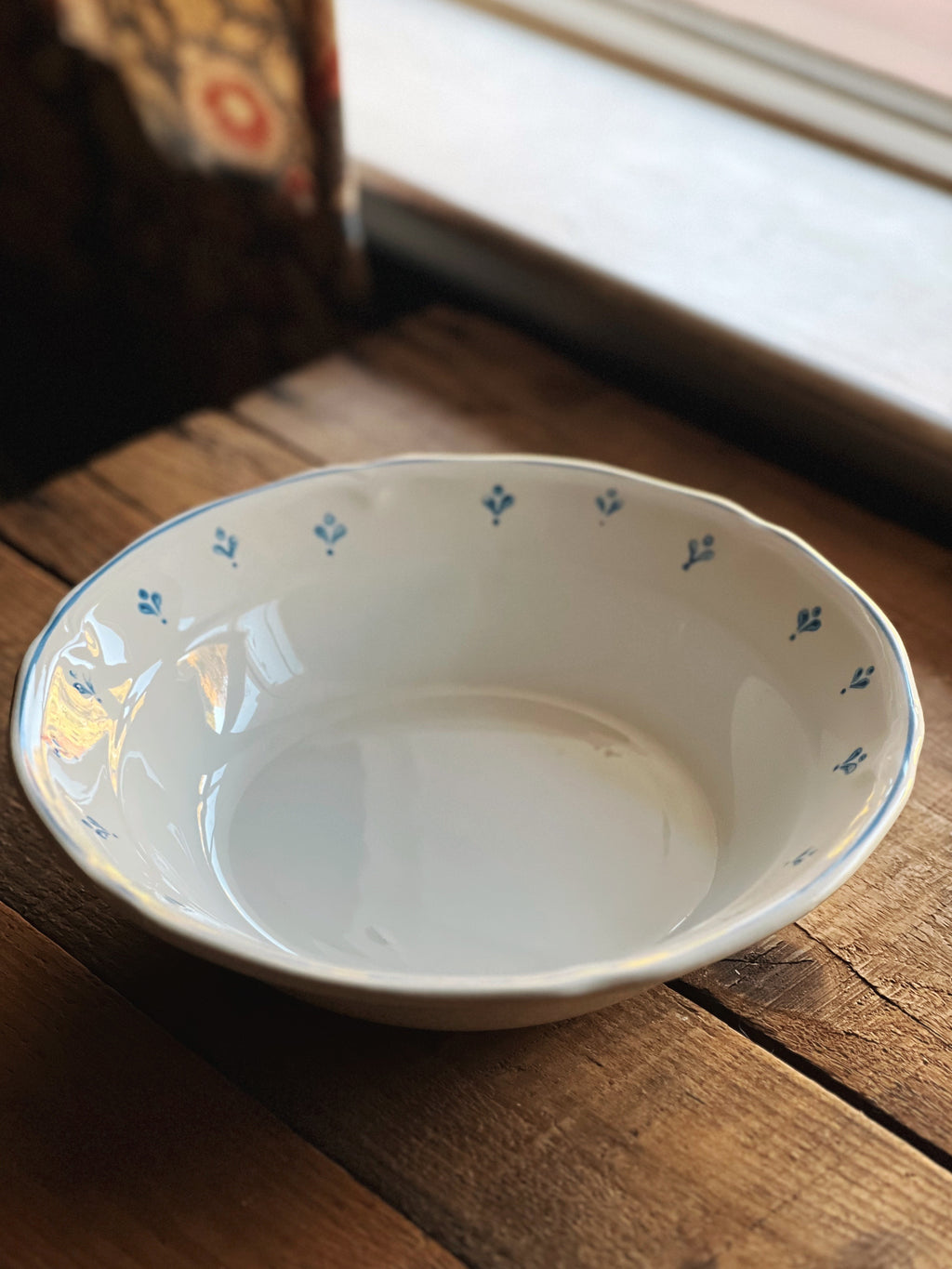 White ceramic bowl with blue floral patterns on a wooden surface