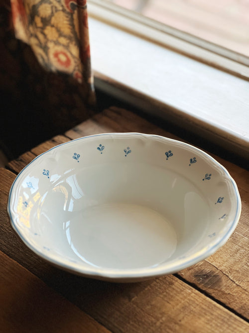 White ceramic bowl with blue floral patterns on a wooden surface