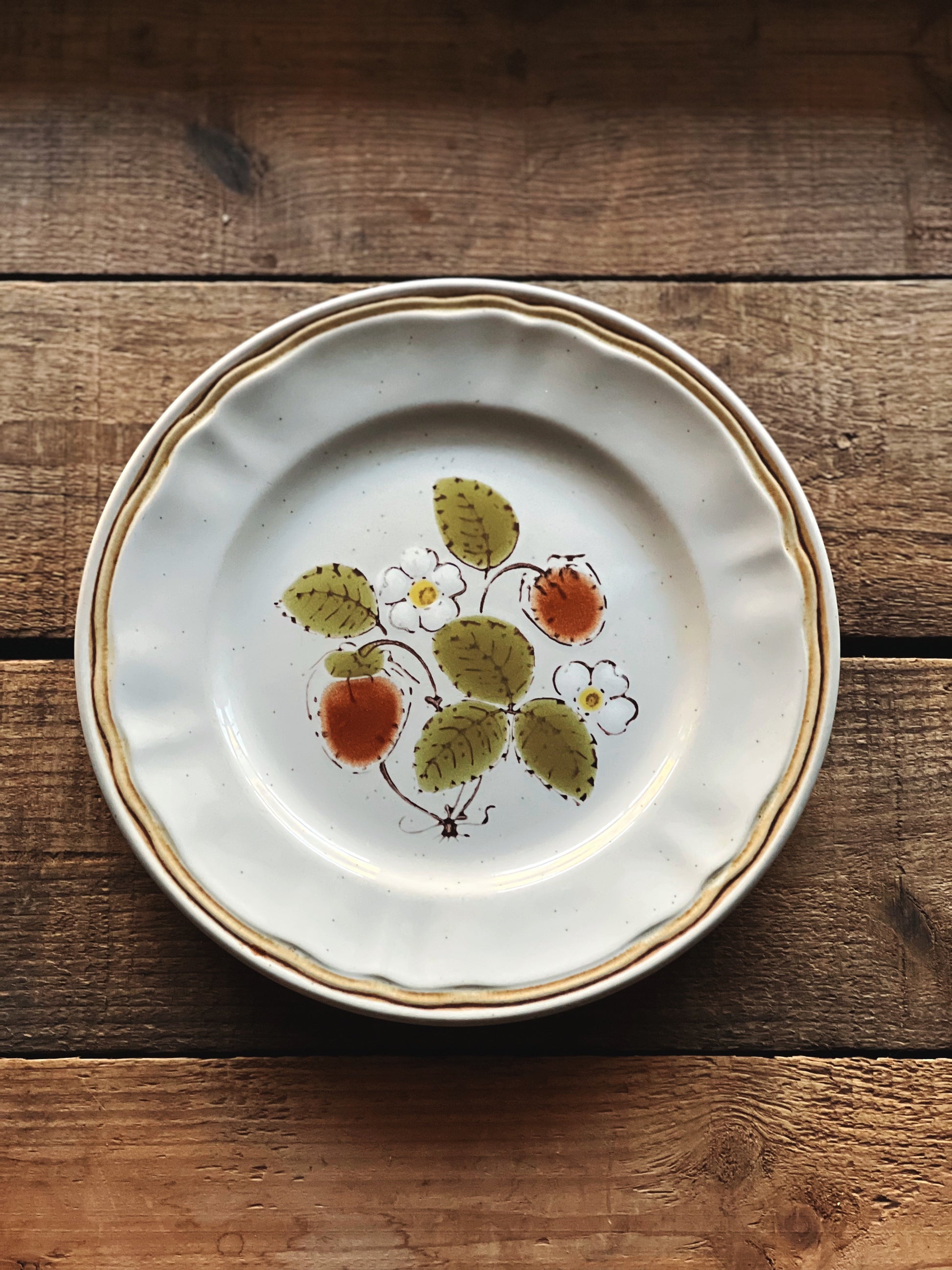 Decorative ceramic plate with floral design on a wooden surface